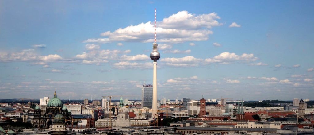 Panoramic view of Berlins skyline with Fernsehturm TV tower under a clear blue sky.