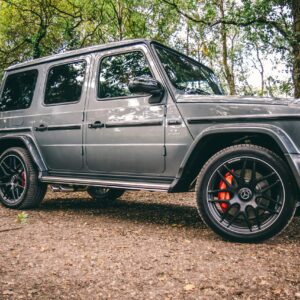 A luxurious Mercedes-Benz SUV parked in a scenic wooded area, showcasing elegance and power.